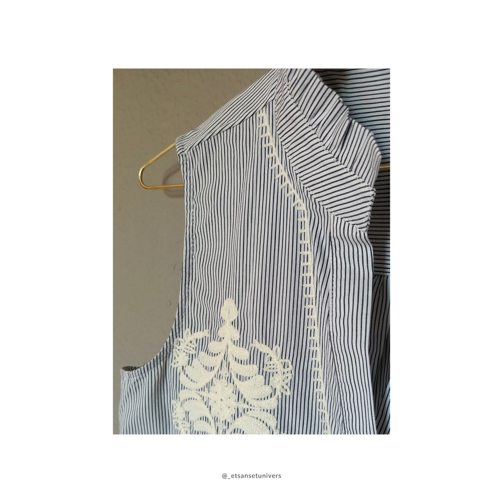 Aleksandrine 100% bomuld vest med broderi i creme hvid og sorte striber, med knapper og flæse krave - set close up af broderi detalje og flæse krave forfra - hos et sanset univers