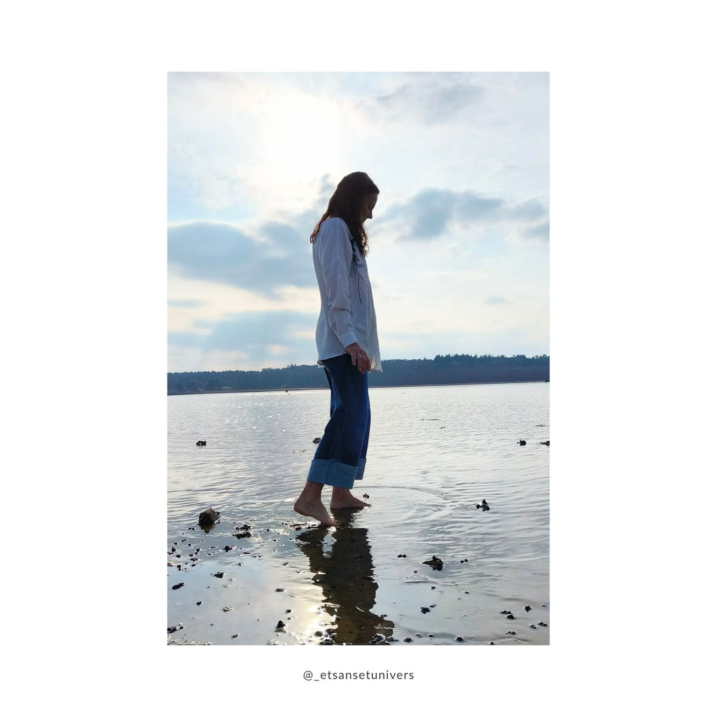 Cropped denim bukser med OEKO-TEX® bomuld og opsmøg/opslag – Helle  med fødderne i vand i hvid skjorte med broderi og de cropped denim bukser ved Frederiksbro ved Roskilde fjord i Frederikssund - Et Sanset Univers